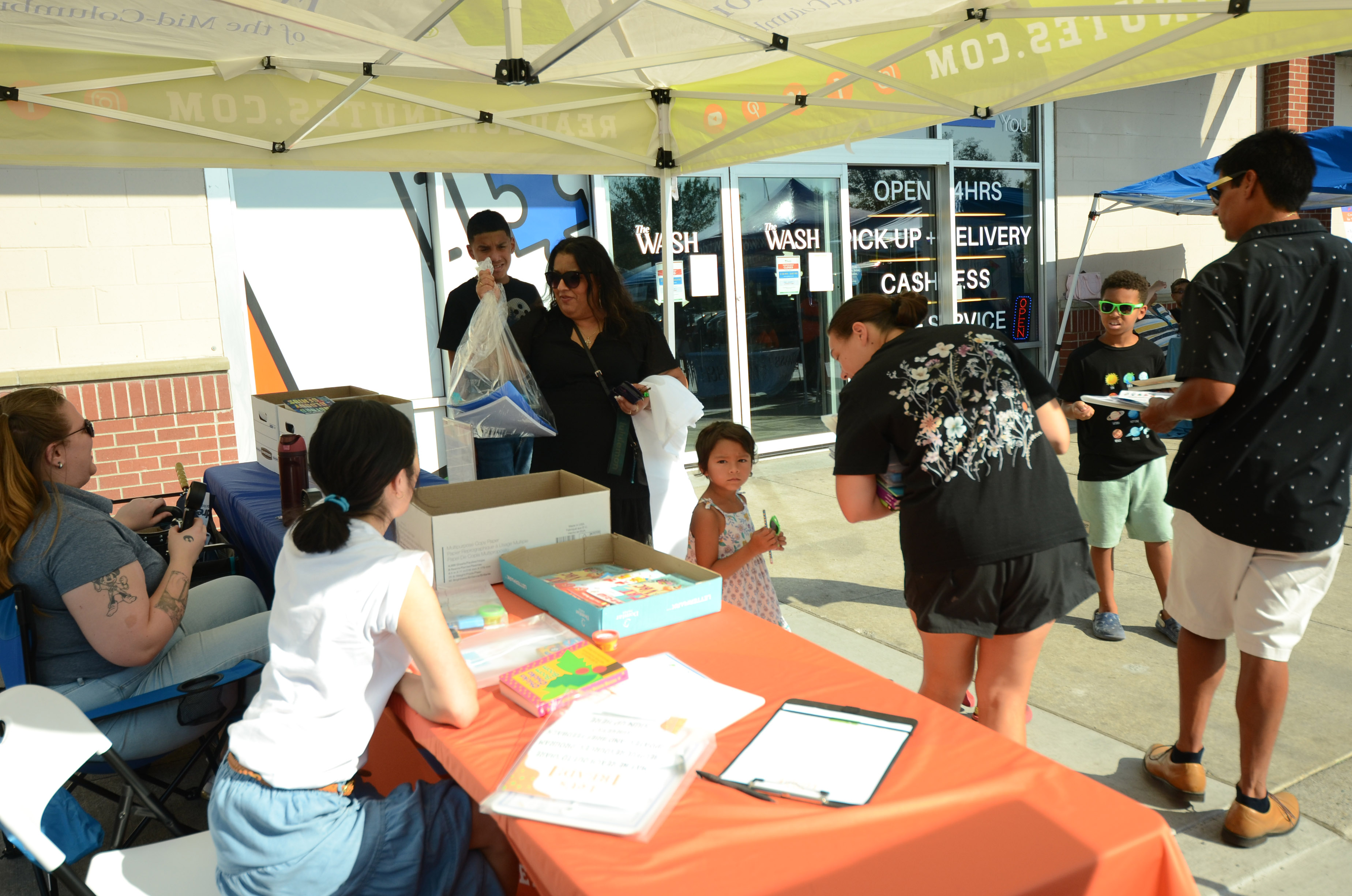 Families and children at the Richland Public Library table during Free Laundry Day