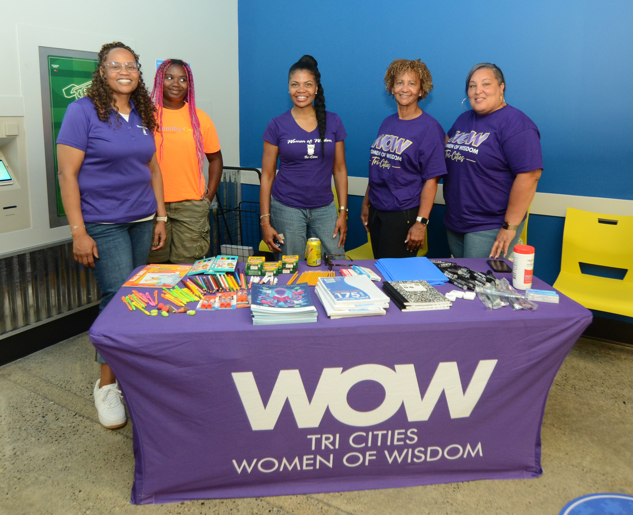 Women of Wisdom Tri-Cities participants behind their resource table