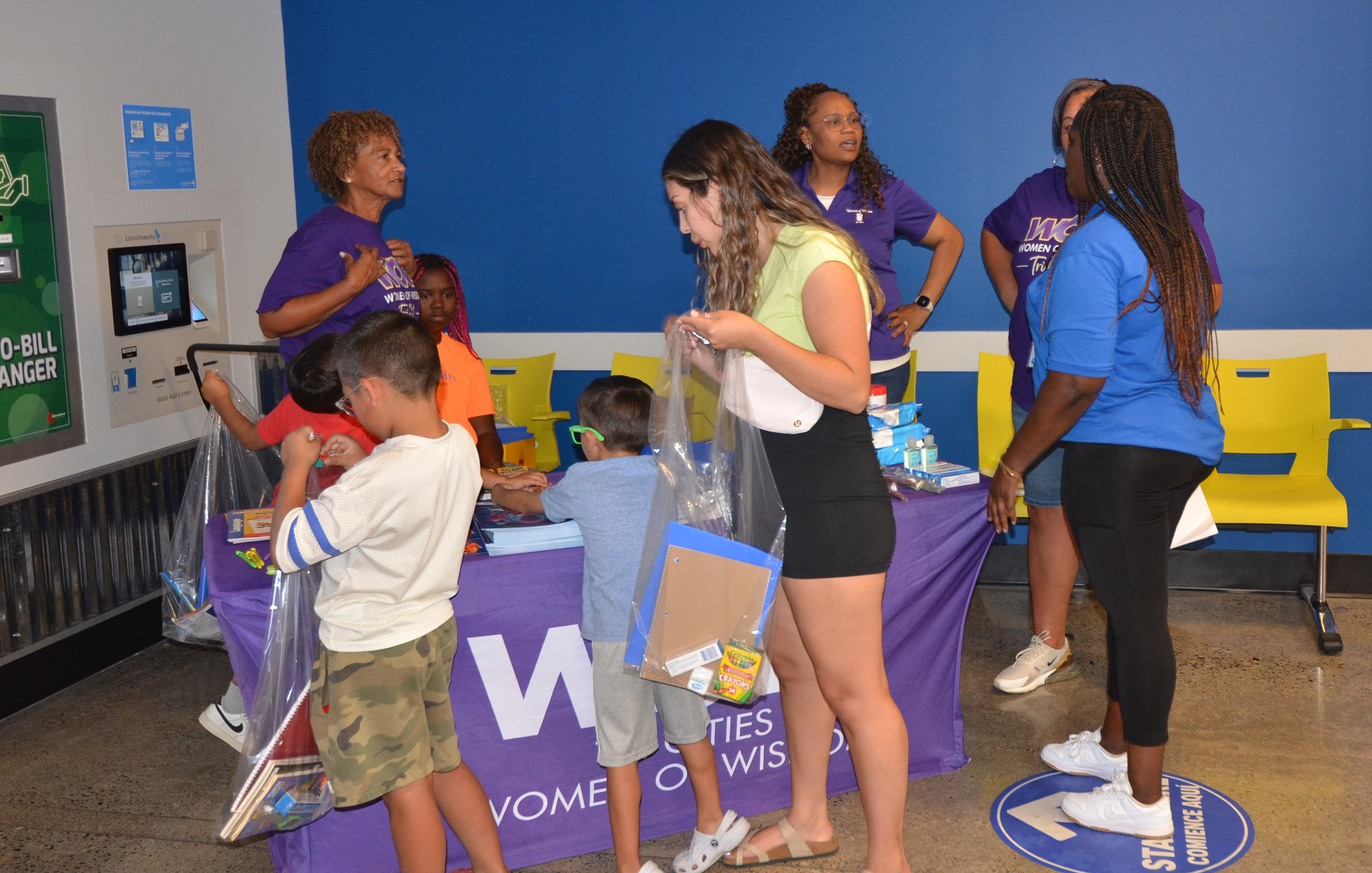 Community resource volunteers speaking with a family inside The Wash