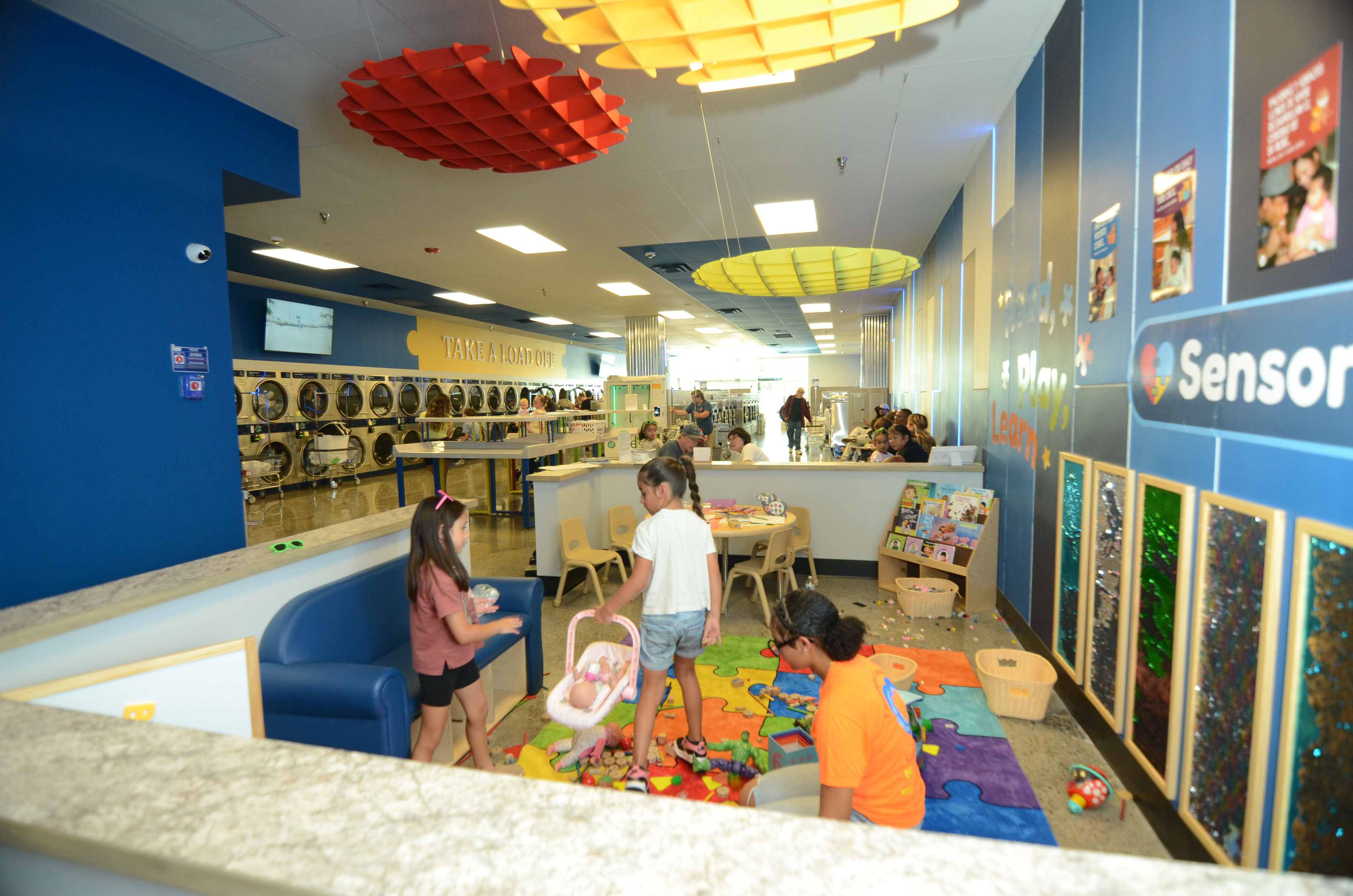 Children and an adult in The Wash’s family activity area