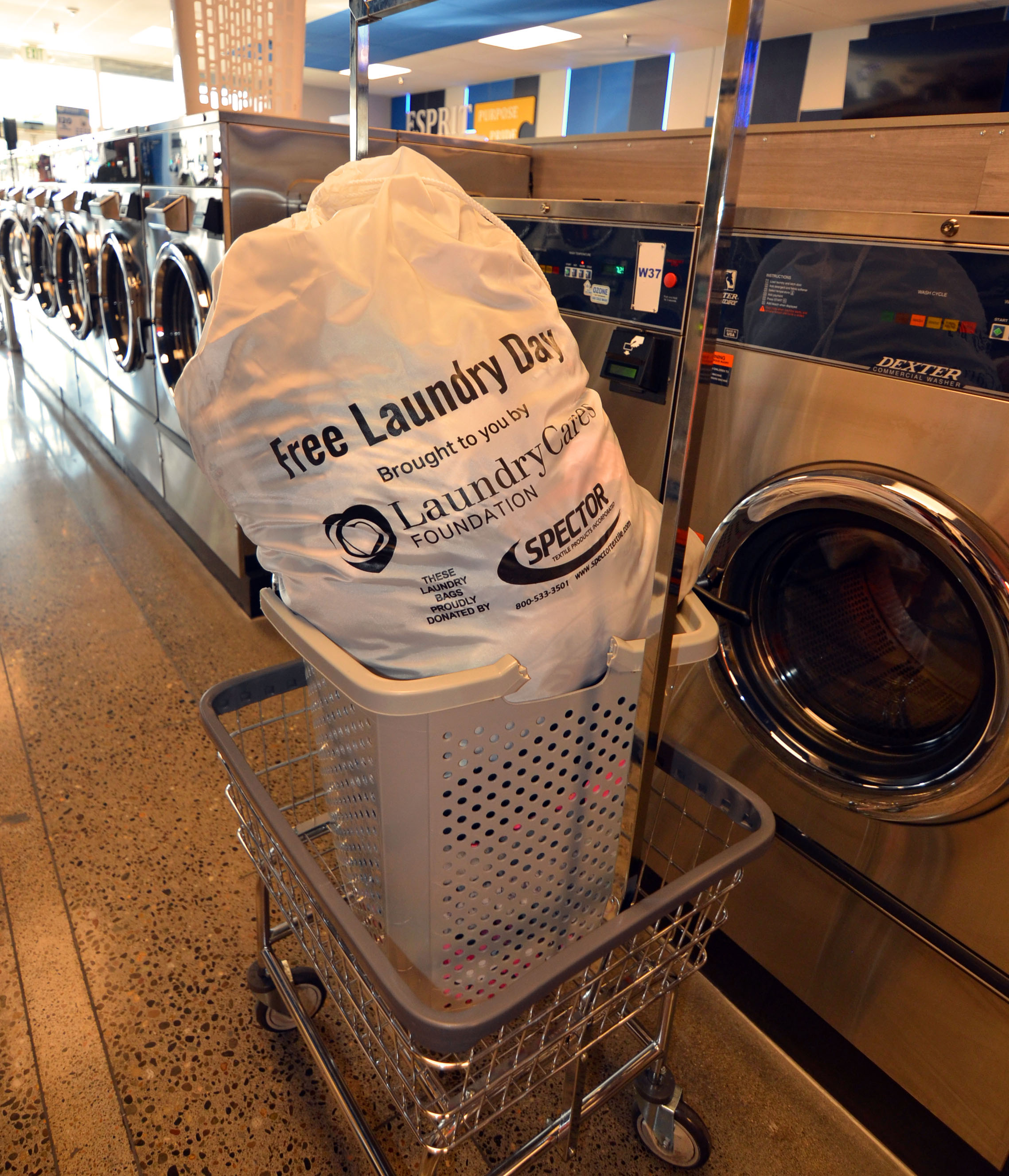 A Free Laundry Day bag in a laundry cart beside the washers